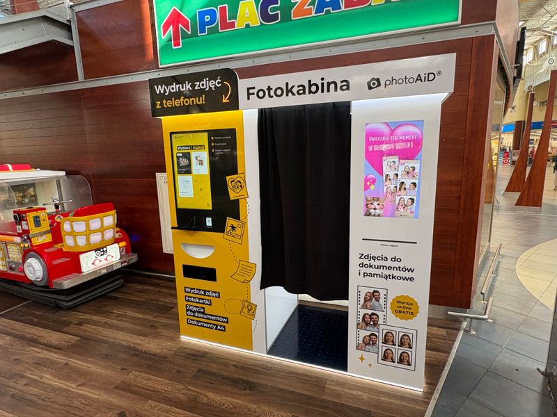 Fotokabina i foto kiosk PhotoAiD pod antresolą z placem zabaw w Auchan Port Rumia