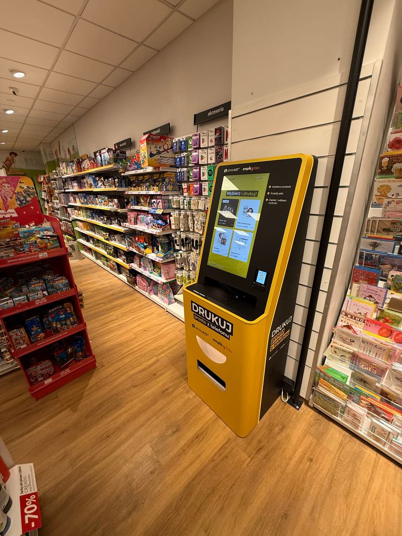 Żółto-czarny foto kiosk PhotoAiD do wydruku zdjęć i dokumentów w Empik Alfa Centrum