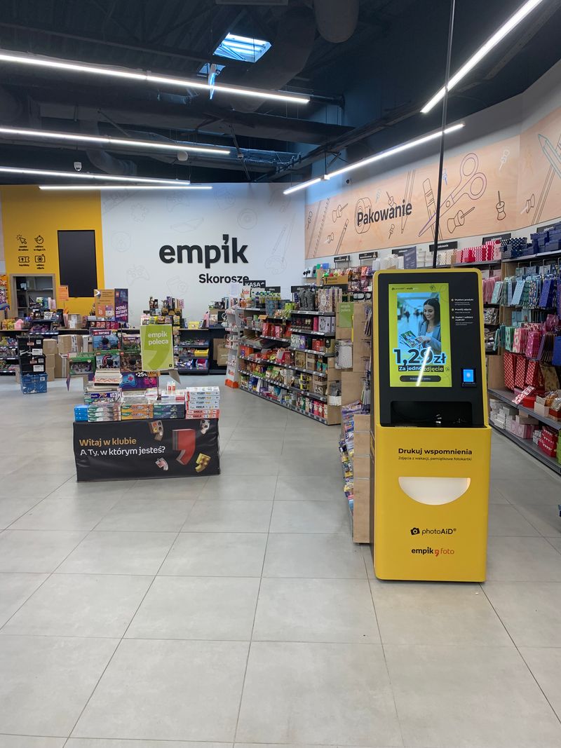 Żółto-czarny foto kiosk PhotoAiD do wywoływania zdjęć w Empik Centrum Skorosze
