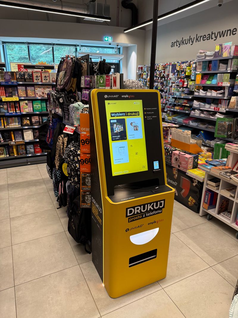 Żółto-czarny foto kiosk PhotoAiD do wydruku zdjęć i dokumentów w Empik CH Viktor w Gdańsku