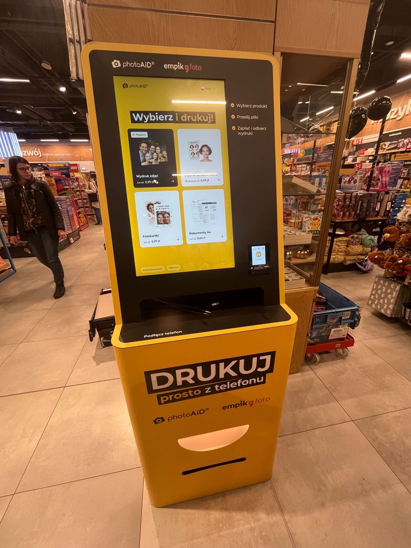 Żółto-czarny foto kiosk PhotoAiD do wydruku zdjęć i dokumentów w Empik Wroclavia