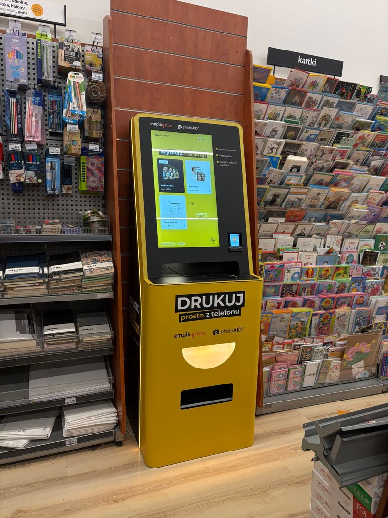 Żółto-czarny foto kiosk PhotoAiD do wydruku zdjęć i dokumentów w Empik Factory Kraków