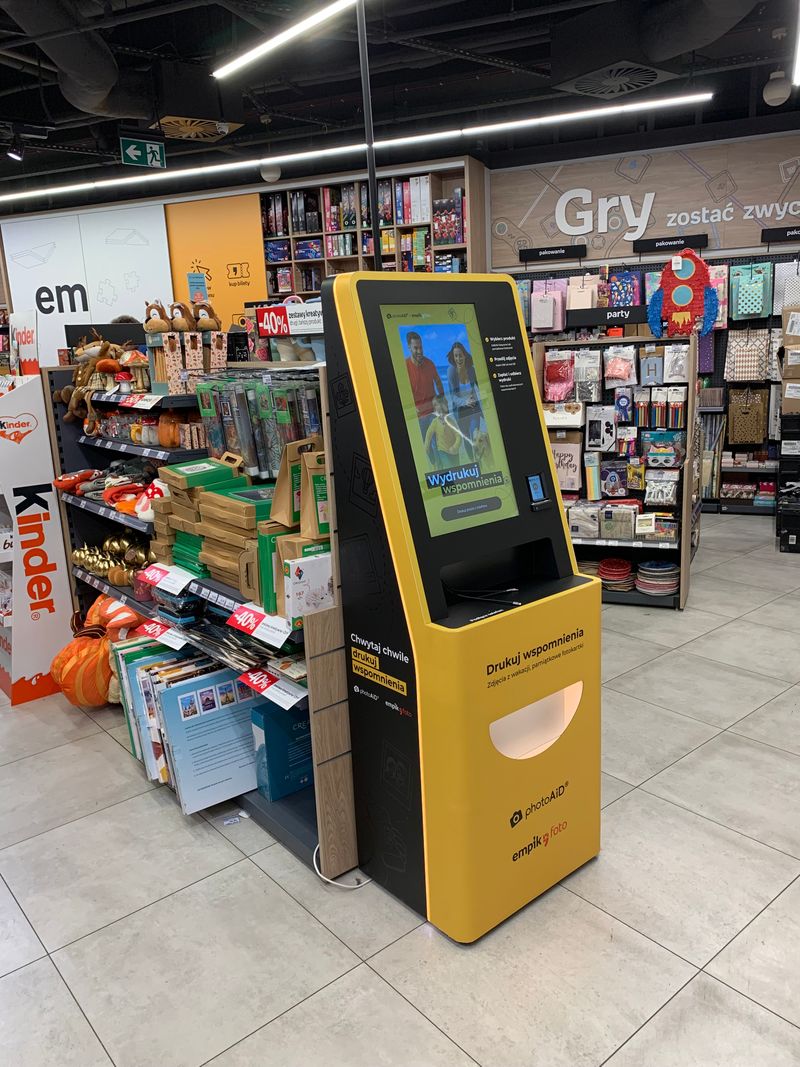 Żółto-czarny foto kiosk PhotoAiD do wydruku zdjęć i dokumentów w Empik Galeria Wileńska