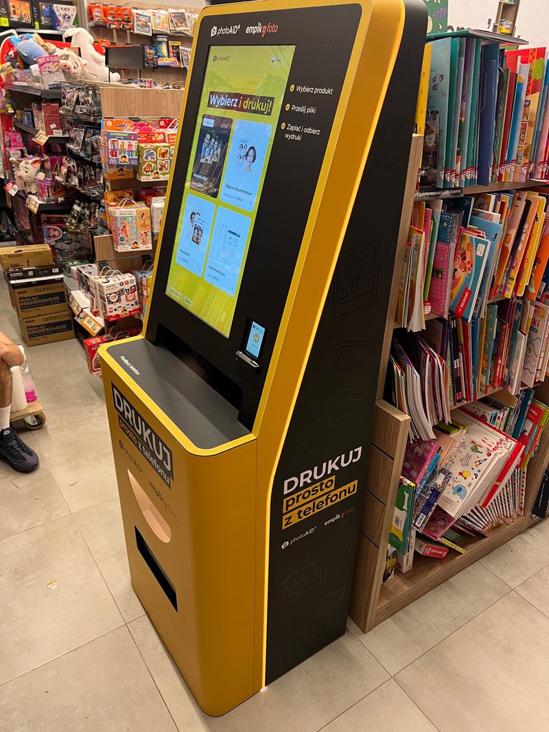 Żółto-czarny foto kiosk PhotoAiD do wydruku zdjęć i dokumentów w Empik Morena