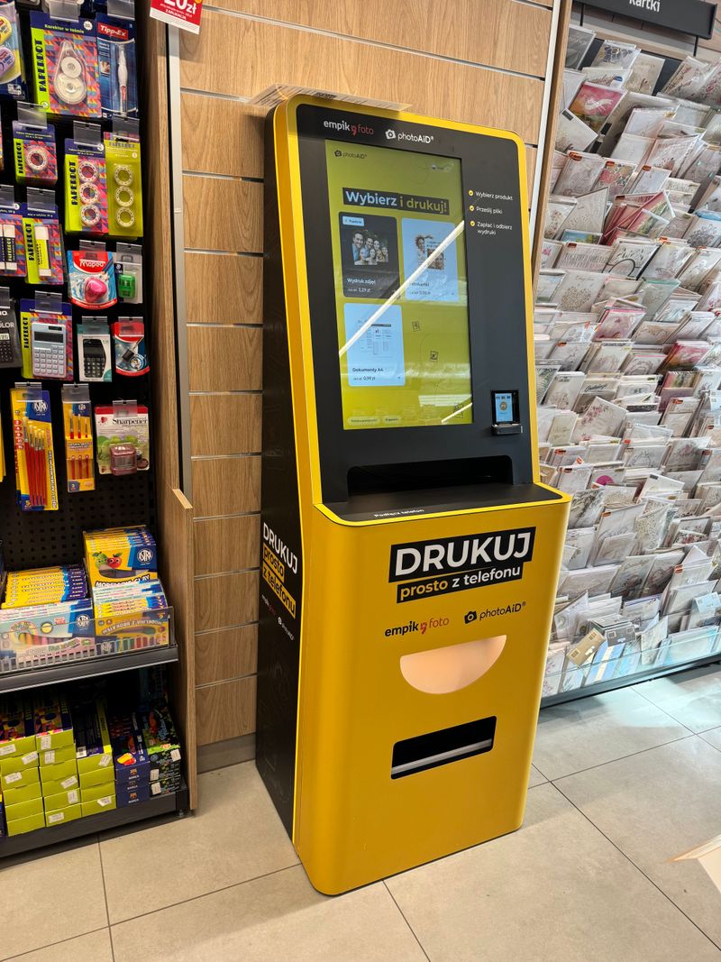 Żółto-czarny foto kiosk PhotoAiD do wydruku zdjęć i dokumentów w Empik Galeria Lębork