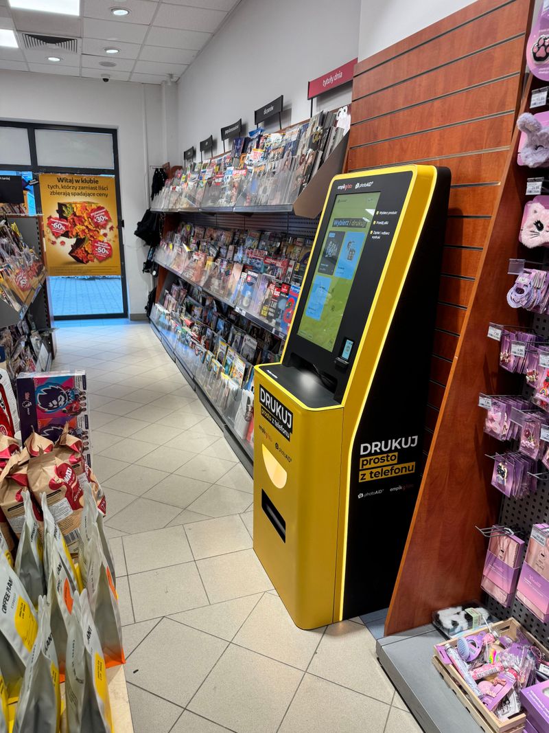 Samoobsługowy foto kiosk PhotoAiD do wywoływania zdjęć przy wejściu do Empiku w Legionowie, widok z boku