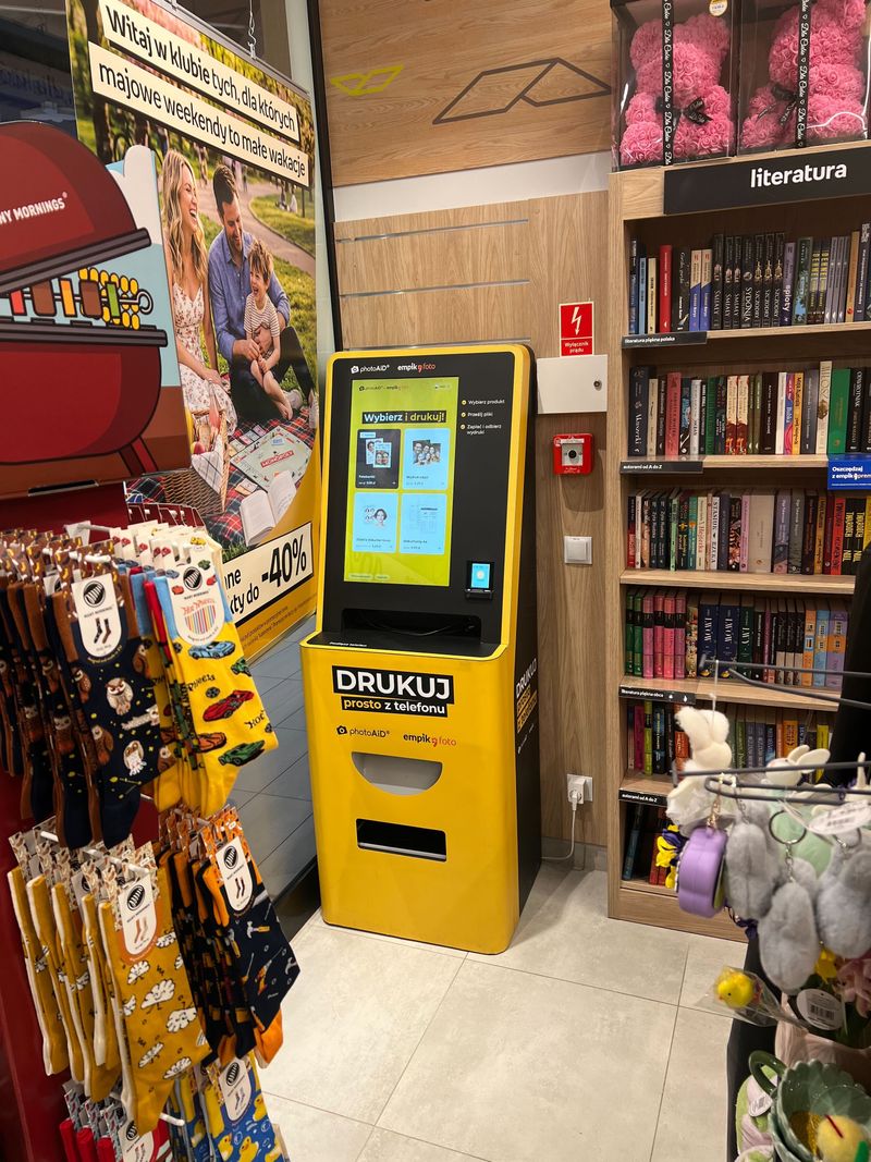 Żółto-czarny foto kiosk PhotoAiD do wydruku zdjęć i dokumentów w Empik Wrocław Marino