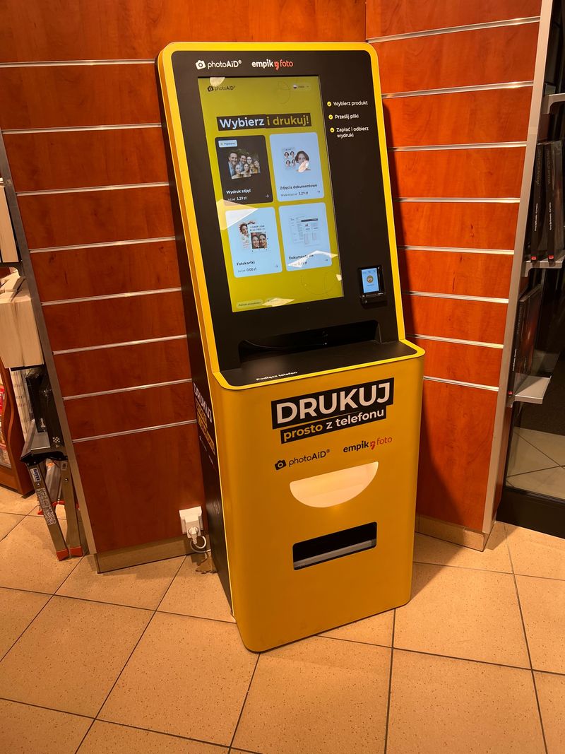 Żółto-czarny foto kiosk PhotoAiD do wydruku zdjęć i dokumentów w Empik Pasaż Grunwaldzki