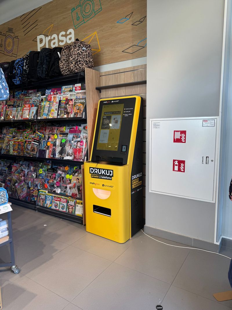Foto kiosk PhotoAiD przy regale z prasą w salonie Empik w parku handlowym w Sędziszowie Małopolskim