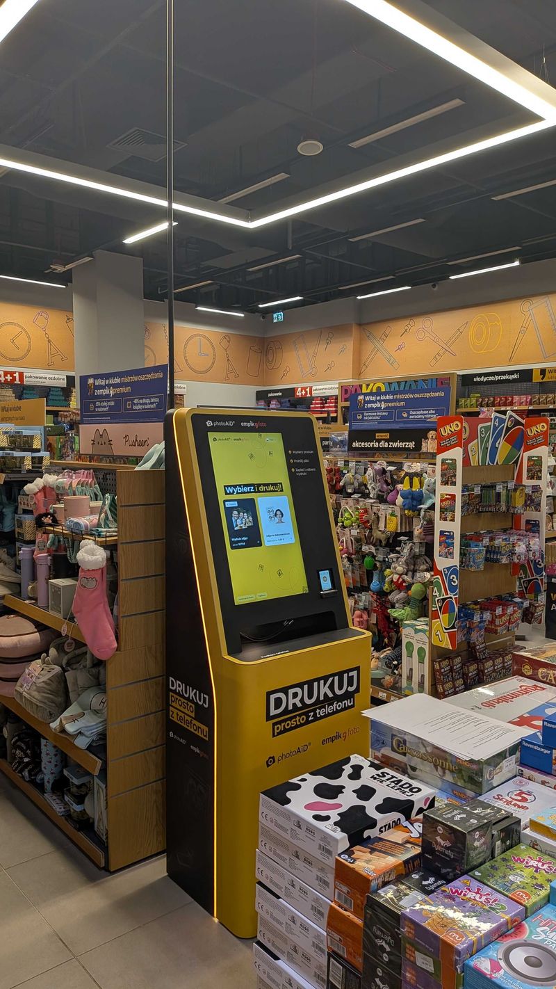 Żółto-czarny foto kiosk PhotoAiD do wydruku zdjęć i dokumentów w Empik Posnania