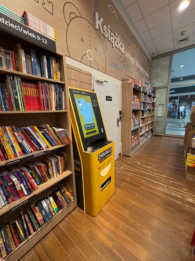 Żółto-czarny foto kiosk PhotoAiD do wydruku zdjęć i dokumentów w Empik Poznań M1