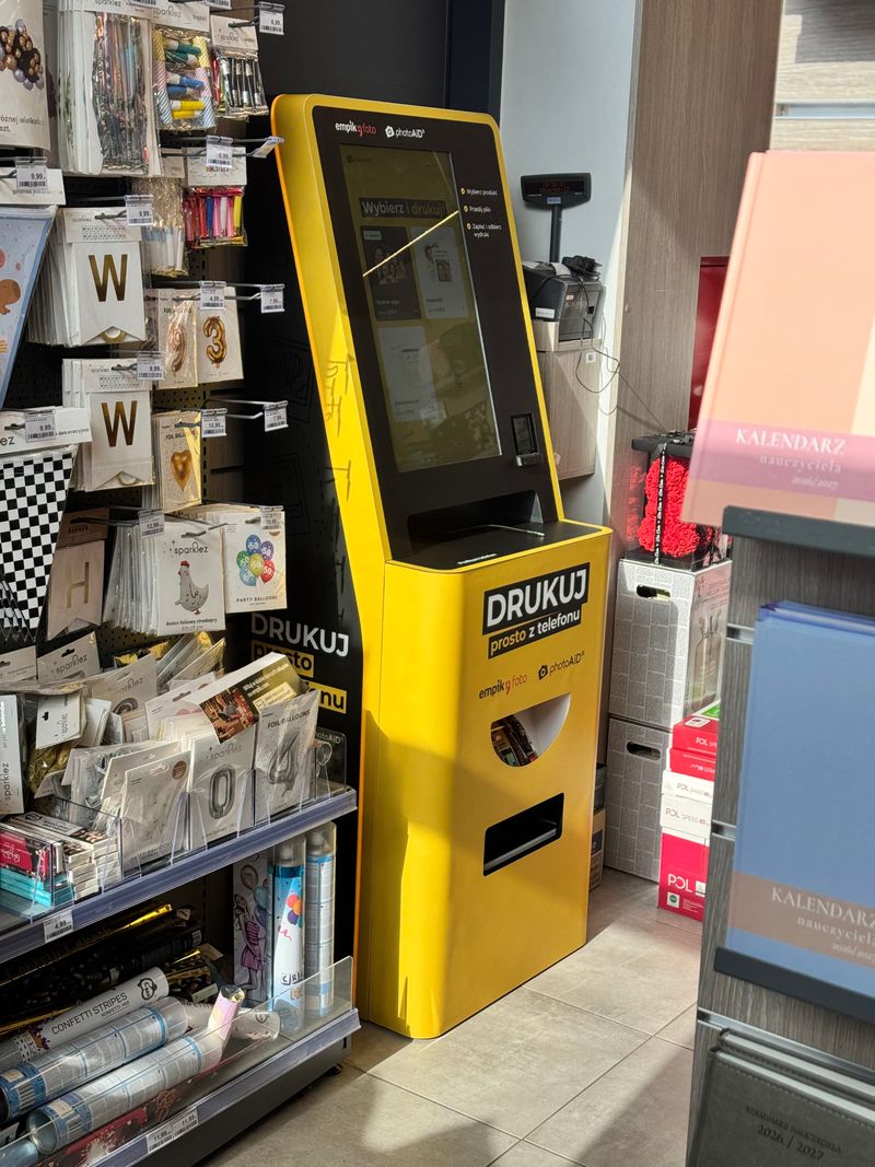 Żółto-czarny foto kiosk PhotoAiD do wydruku zdjęć i dokumentów w Empik Rembertów