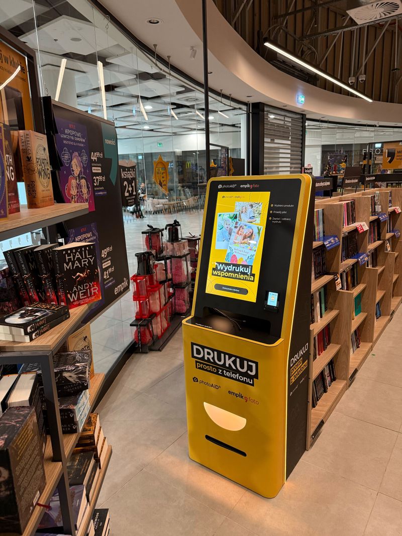 Żółto-czarny foto kiosk PhotoAiD do wydruku zdjęć i dokumentów w Empik Sky Tower