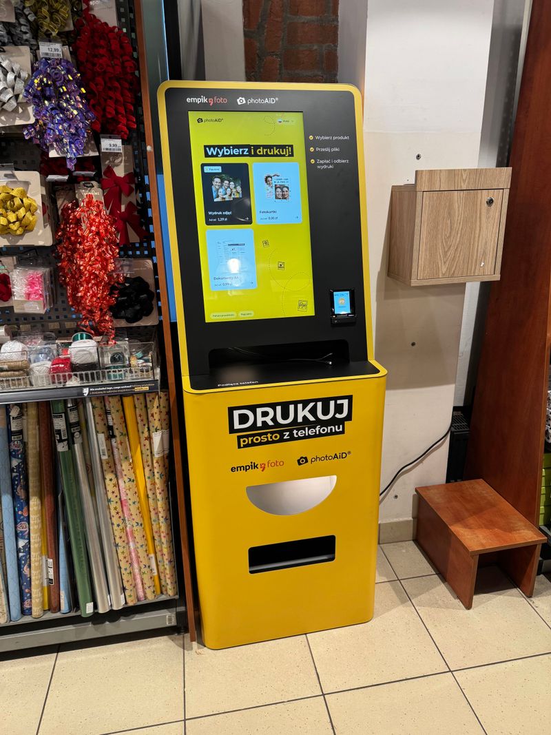 Foto kiosk PhotoAiD w salonie Empik w Starej Przędzalni w Żyrardowie z ekranem wyboru wydruku zdjęć i dokumentów A4