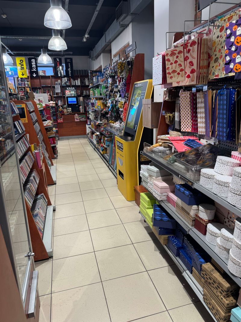 Foto kiosk PhotoAiD w alejce salonu Empik Stara Przędzalnia, w głębi kasa i punkt informacji