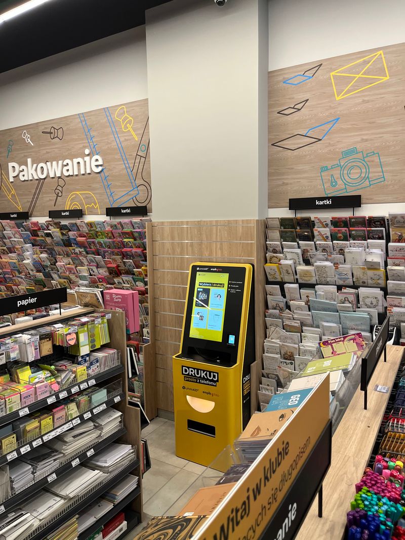 Żółto-czarny foto kiosk PhotoAiD do wydruku zdjęć i dokumentów w Empik Toruń Plaza