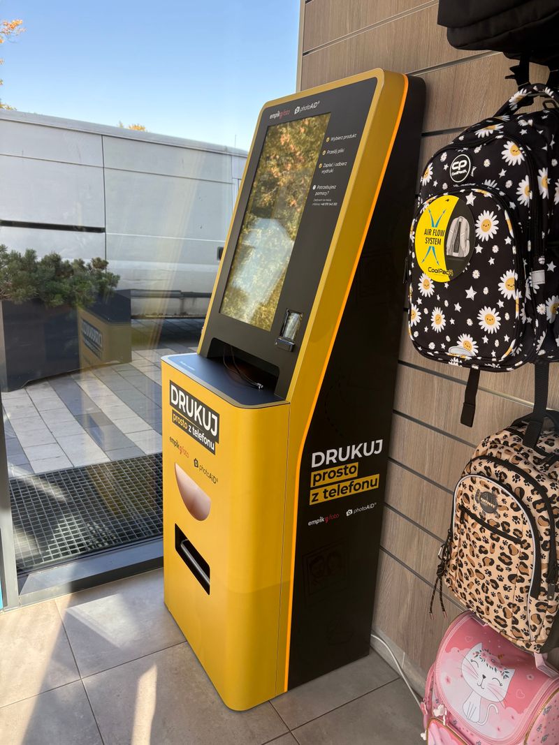 Żółto-czarny foto kiosk PhotoAiD do wydruku zdjęć prosto z telefonu w Empik Warszawa Bokserska