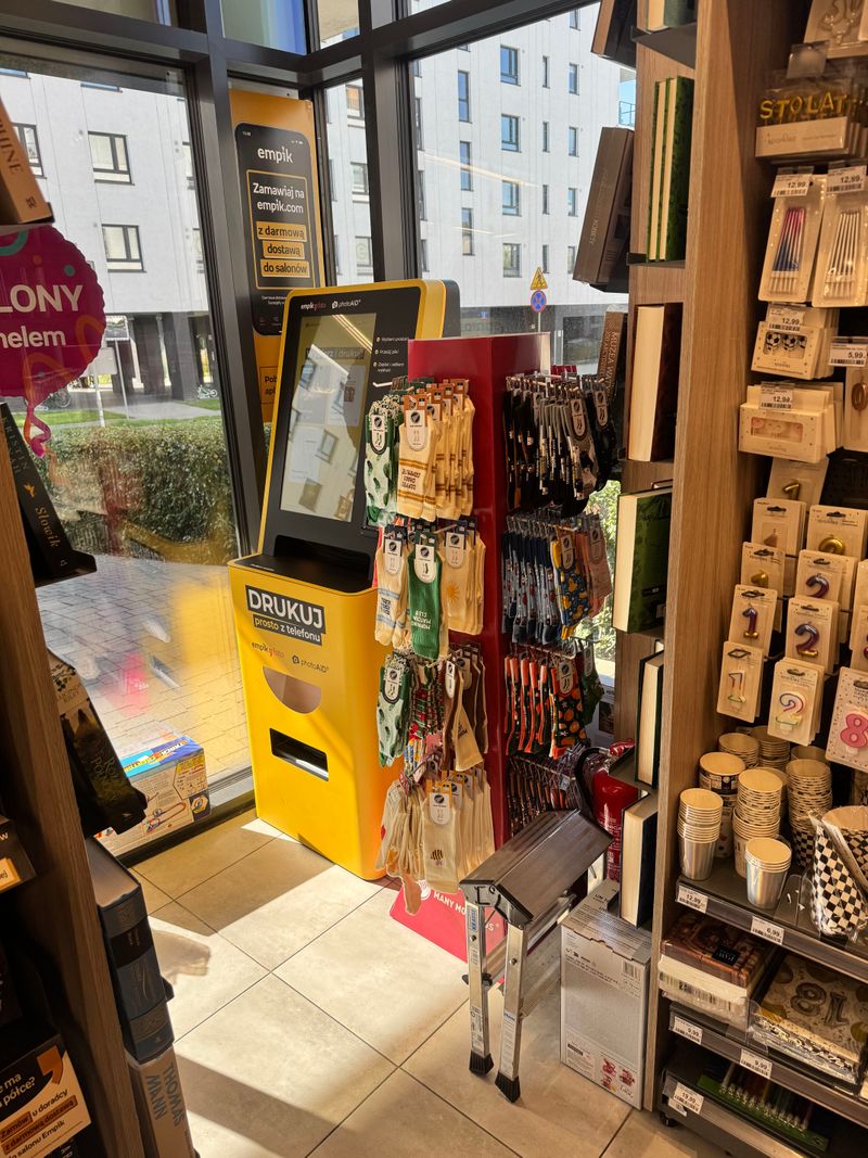 Foto kiosk PhotoAiD do wywoływania zdjęć i druku dokumentów A4 przy witrynie Empik Pełczyńskiego