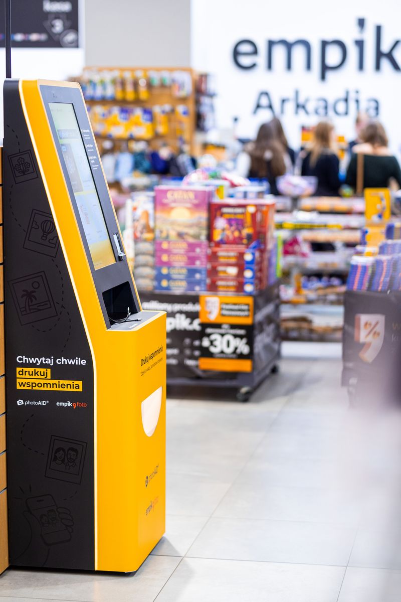 Żółto-czarny kiosk PhotoAiD do wydruku zdjęć i dokumentów w Empik Arkadia